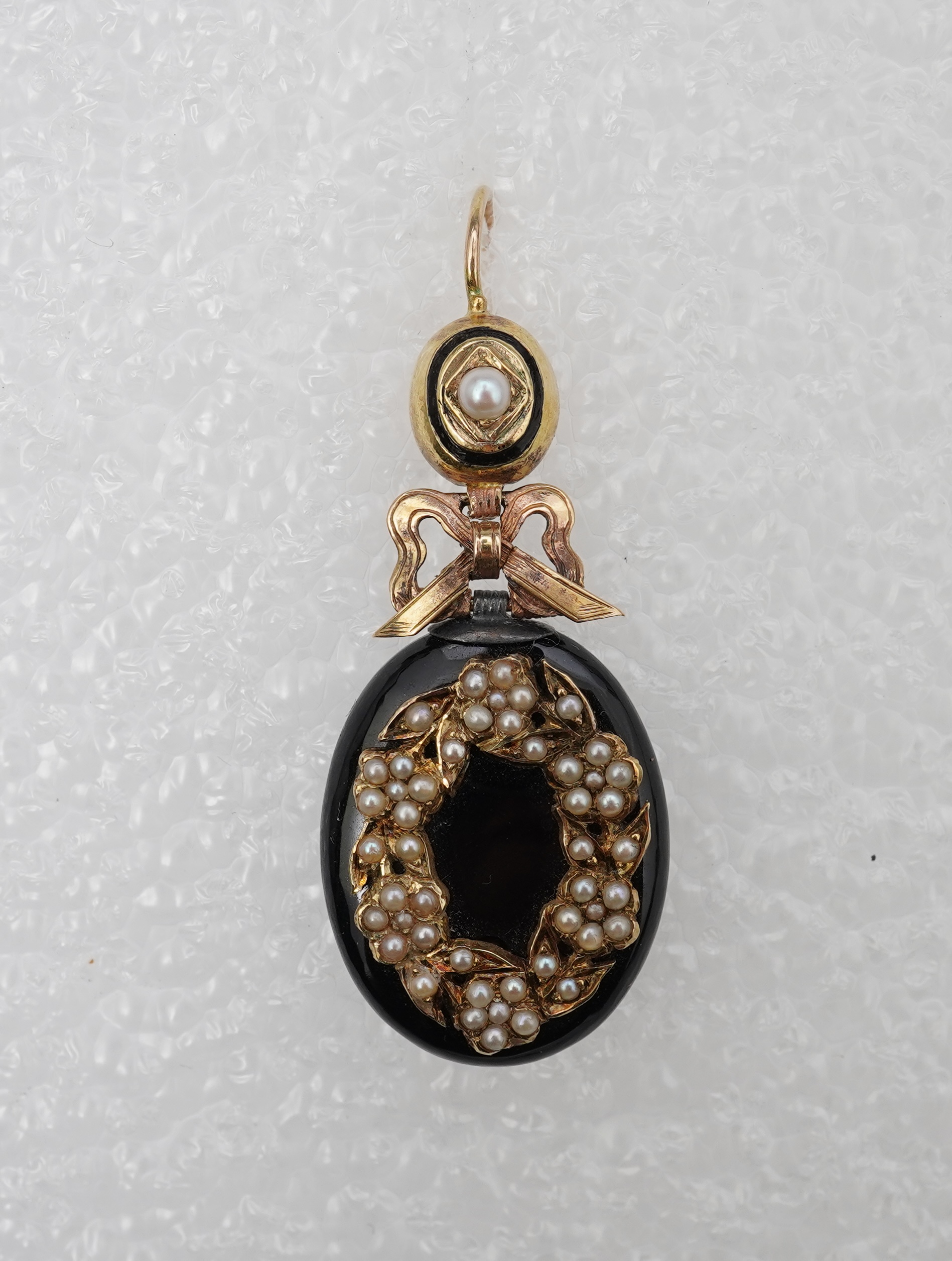 An onyx and seed pearl mourning locket pendant, late 19th century